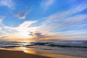 Sunset over the sea. Reflection of sunlight in the sea waves. The sky in the sunset rays.