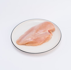 Raw chicken breast fillets on white dish
