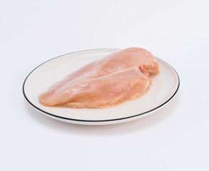 Raw chicken breast fillets on white dish