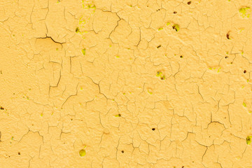 Fragment of an old decayed wall. The cracked yellow plaster. Soft focus.