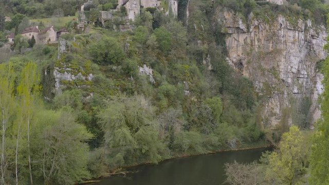 Aerial view showing Saint Cirq Lapopie altitud. From Lot river to top of mountain cliff. Village is built on the top. Quercy region, Occitanie, southern France 