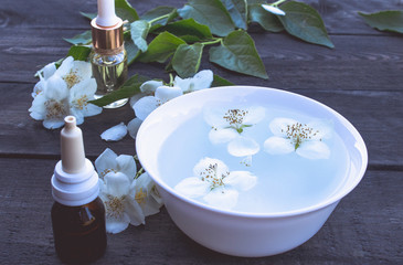 Obraz na płótnie Canvas Essential aromatic oil with jasmine on wooden background.