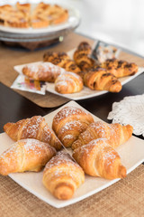 Breakfast buffet table filled with croissant and homemade cake
