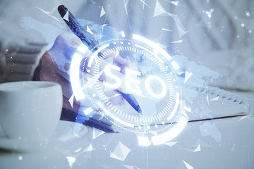 Multi exposure of woman's hands making notes with SEO icon. Concept of Search engine optimization
