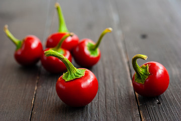 cherry peppers on old black wooden table background
