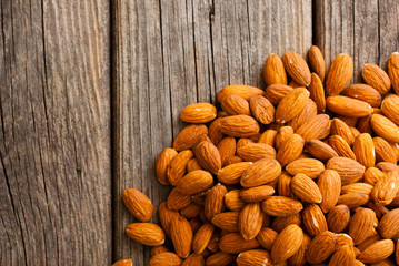 peeled almonds on old wooden table, top view