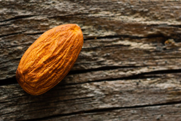 one peeled almond on old wood table