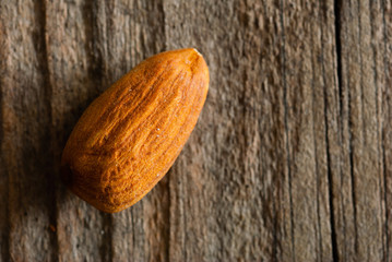 one peeled almond on old wood table