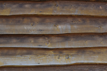 Textured wooden wall, country house close-up. front view. background of wooden planks, folded horizontally.