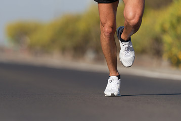 Sport and fitness runner man running on road training for marathon run doing high intensity...