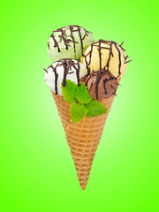 Waffle cone with different scoops of ice cream decorated with mint and chocolate sauce on color background