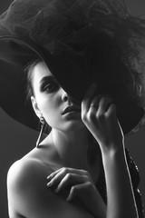 Obraz premium high fashion portrait of elegant woman in black and white hat and dress.