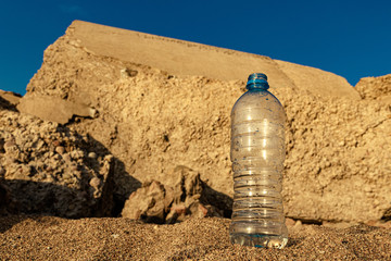 plastic bottle on the sea sand. water saving.