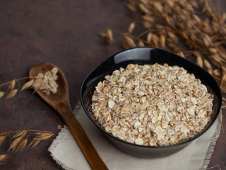 Oat flakes and ears of oats. Oatmeal in a plate on the table. Healthy breakfast