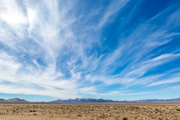 Wispy clouds over a vast desert landscape, along the Extraterrestrial Highway in Nevada - Powered by Adobe