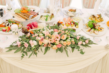 Flower arrangement of fresh flowers eustoma, roses, eucalyptus on the table the newlyweds at the wedding Banquet