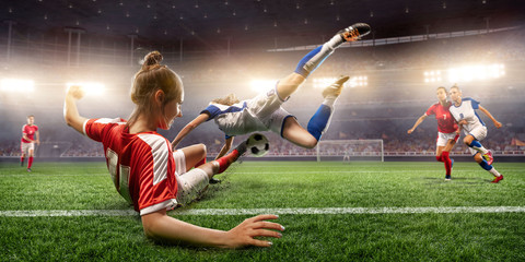 Female Soccer players performs an action play on a professional soccer stadium. Girls playing soccer