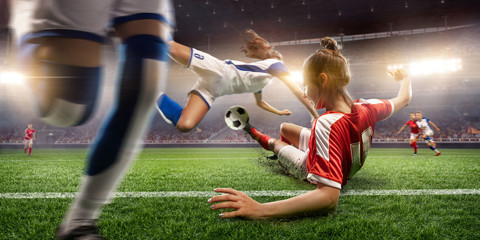 Female Soccer players performs an action play on a professional soccer stadium. Girls playing soccer