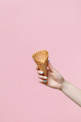 Woman holding waffle cones on color background.