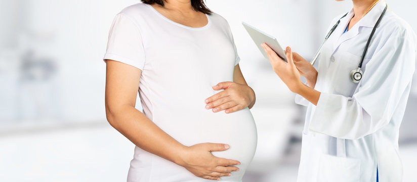 Happy pregnant woman visit gynecologist doctor at hospital or medical clinic for pregnancy consultant. Doctor examine pregnant belly for baby and mother healthcare check up. Gynecology concept.