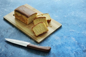 Homemade banana bread slice on a blue background.