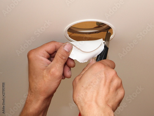 Men Hands Cutting A Hole For The Recessed Spot Light In The
