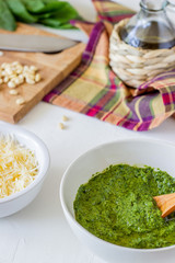 Pesto sauce and ingedients on a white background. Italian cuisine. Vegetarian food. The diet.