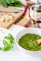 Pesto sauce and ingedients on a white background. Italian cuisine. Vegetarian food. The diet.