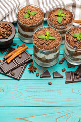Classic tiramisu dessert in a glass on blue wooden background