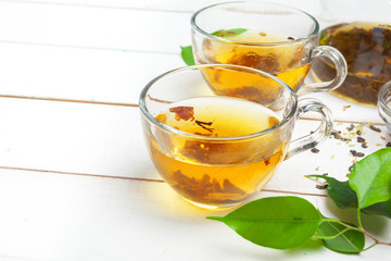 teapot and cups of tea on a white wooden background