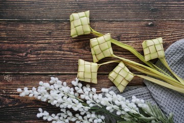 Ketupat (Rice Dumpling) On Wooden Background. Ketupat is a natural rice casing made from young coconut leaves for cooking rice during eid Mubarak, Fitri 