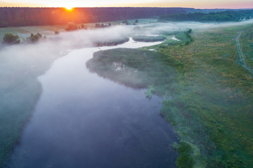 Early misty morning, sunrise over the lake. Rural landscape in summer. Aerial view