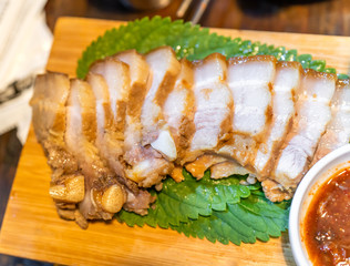 Pan-fried cooked black pork meal in Korea restaurant, fresh delicious korean food cuisine on iron plate with lettuce, close up, copy space, lifestyle