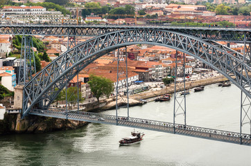 Fototapeta premium Riverboat sailing on the river Douro, with double-deck metal arch bridge. Porto.