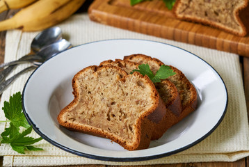Slices of homemade banana bread in a white plate on a wooden table