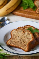 Slices of homemade banana bread in a white plate on a wooden table