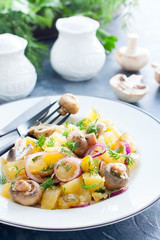Potato salad with marinated champignons on a white plate, selective focus