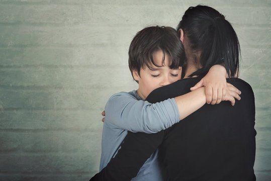 Sad child hugging his mother