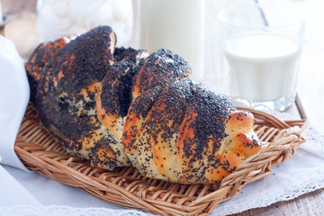 Homemade challah with poppy seeds in a wicker tray, horizontal