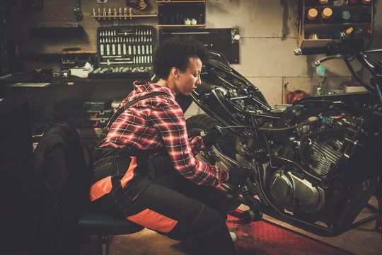 African American Woman Mechanic Repairing A Motorcycle In A Workshop