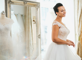 Beautifu bride choosing wedding dress in a wedding salon