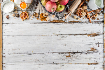 Autumn baking sale concept. Cooking seasonal fall baking background with ingredients, spices, apples, supplies, white wooden table top view copy space