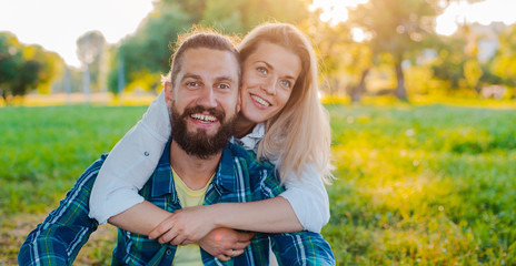 Fototapeta premium happy young couple in love in nature. Married couple family hugs at sunset background.
