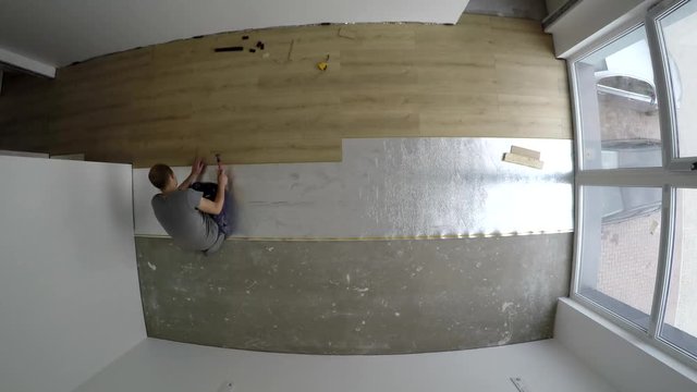Skilled men laying laminate flooring in new room at home. timelapse