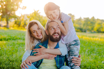 Happy young family spending time together outside in green nature.