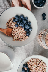 Top view of breakfast table, crunchy granola with fresh berries and cream or milk. Flat lay, healthy eating.