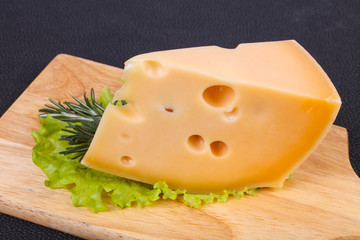 Maasdam cheese  in the board served salad leaves