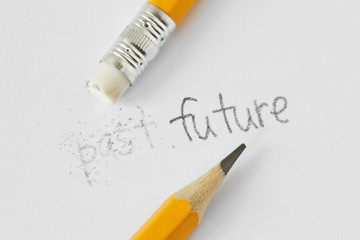 The word past erased with a rubber and the word future written with a pencil on white paper -...