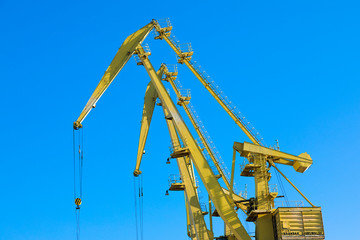 Mobile harbor cranes over blue sky. Transport and technology concept
