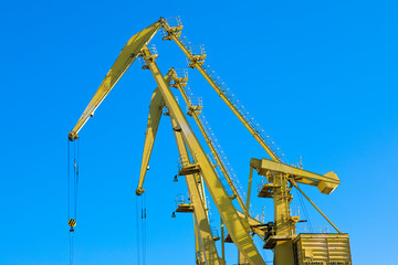 Mobile harbor cranes over blue sky. Transport and technology concept